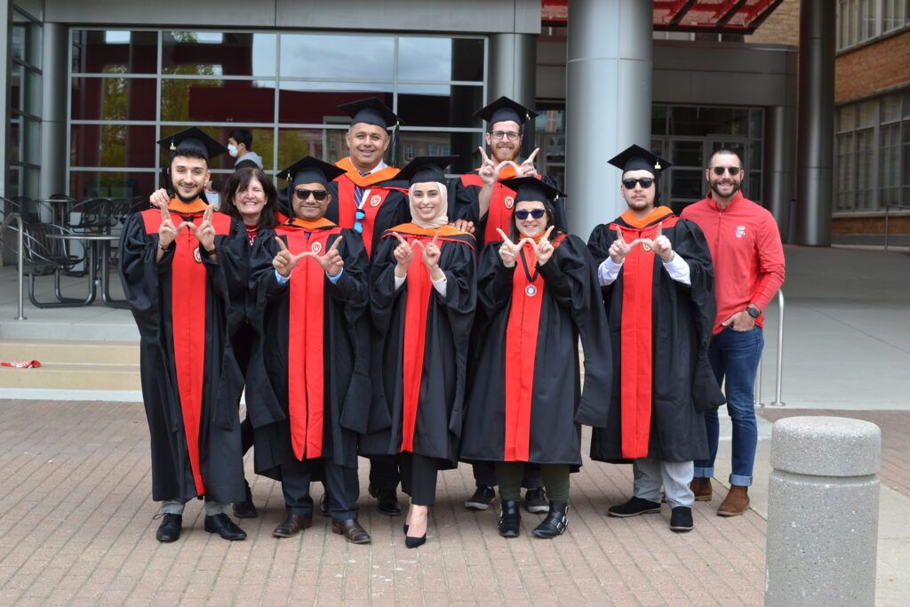 A smiling group of engineering graduates in their caps and gowns.