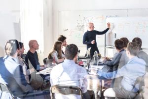 An instructor presents to a group of professionals, fostering an interactive learning environment.