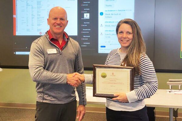 Student receiving certification from Program Director Jon Wellik