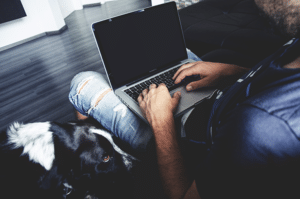 man working on laptop sitting on a couch